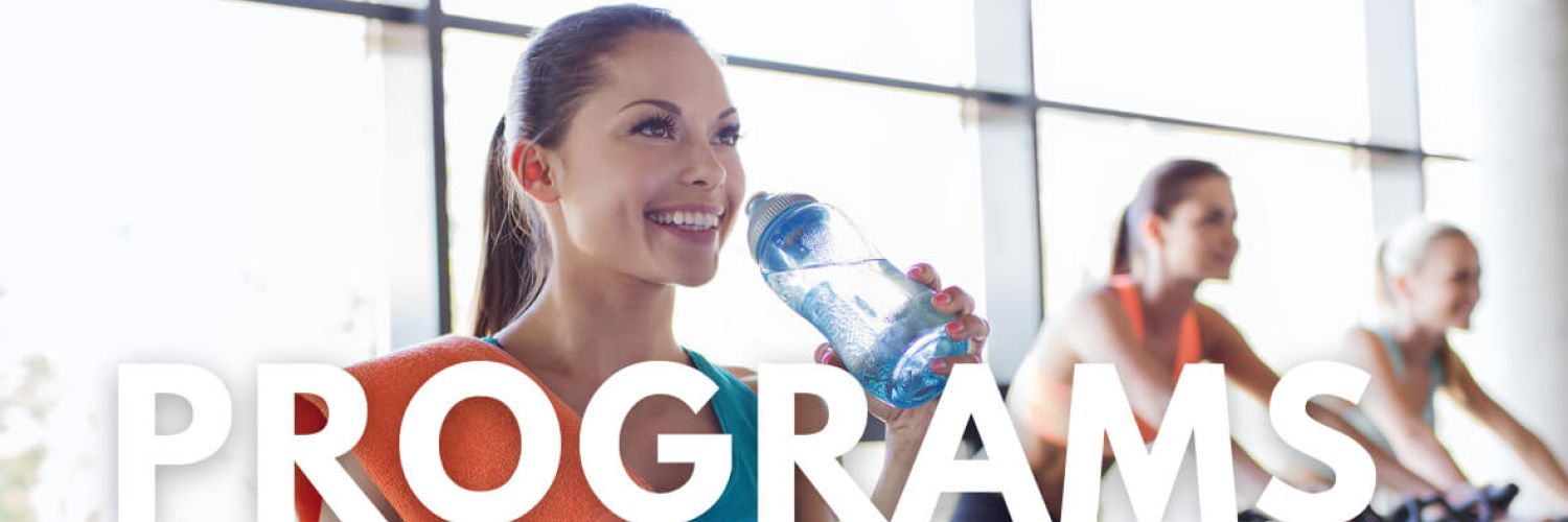 Programs hero image woman at gym smiling drinking water bottle