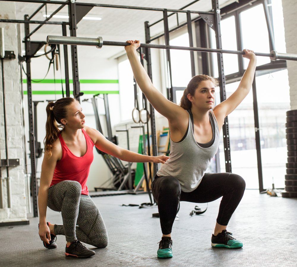 female personal trainer watching woman client on chest exercise equipment at Lifestyle Gym Nanaimo